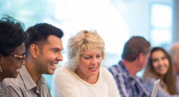 Adult learning group looking at laptop